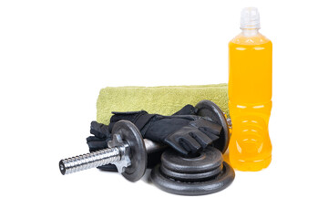 Fitness set including a metal dumbbell, black training gloves, a green towel, and a bottle of orange sports drink, all isolated on a white background. The arrangement highlights essential gym accessor