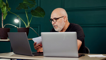 Businessman in a modern office working on a laptop. Concept of productivity and success in a...