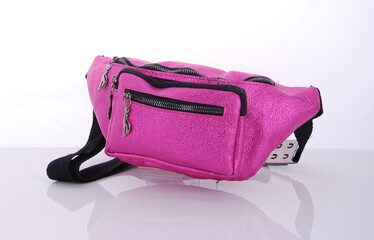 Stylish pink fanny pack with multiple zippered compartments displayed on a white surface for a...