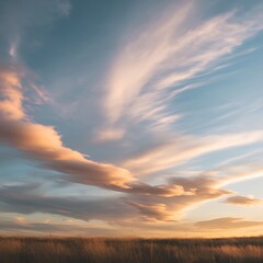 Obraz premium Photo of wispy clouds paint the sky with pastel colors during a serene sunset over a grassy field