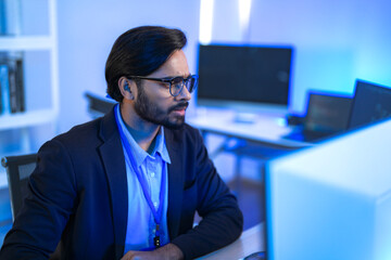 Focused Indian male AI developer coding a complex machine learning algorithm late at night. A...