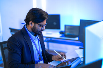 Focused Indian male AI developer coding a complex machine learning algorithm late at night. A...