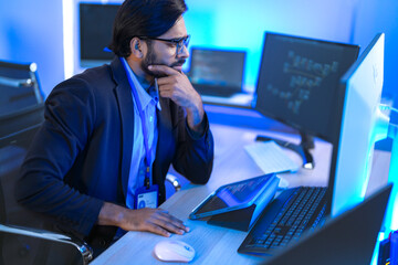 Focused Indian male AI developer coding a complex machine learning algorithm late at night. A...