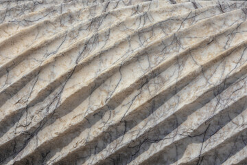 Spiral sculptural relief on the surface of a column in the ancient city of Perge in Turkey. Antique columns subject to erosion and ruins of an ancient city. Background of the column surface.