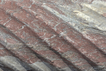 Spiral sculptural relief on the surface of a column in the ancient city of Perge in Turkey. Antique columns subject to erosion and ruins of an ancient city. Background of the column surface.