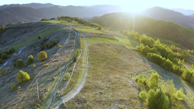 Ukraine, drone, flight in the Carpathians early in the autumn morning at sunrise near the city of Kosiv. Bright forests and dwellings of the Hutsul highlanders on the glades
