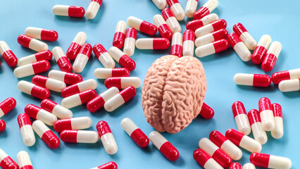 Brain Model and Red and White Capsules on Blue Background