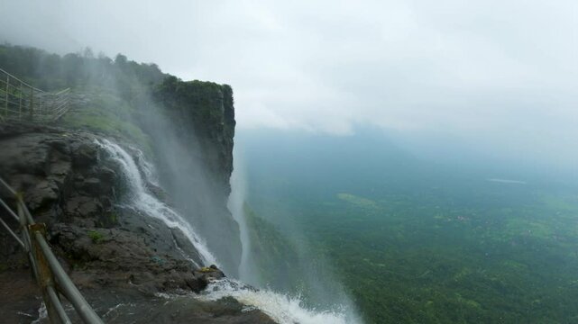 4K shot of reverse waterfall at Naneghat in Maharashtra, India during the monsoon season. Waterfall flows in reverse due to the strong winds in Sahyadri hills. Natural background with copy space.