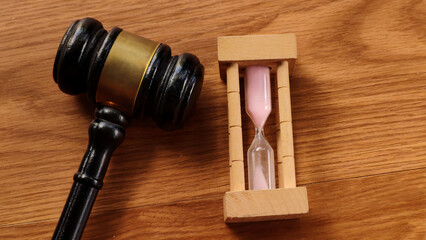 Gavel and Hourglass on Wooden Table