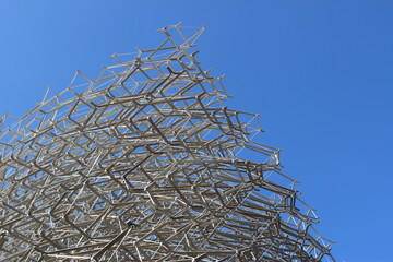 Geometric Metallic Lattice Structure Against Clear Blue Sky, Modern Architectural Design