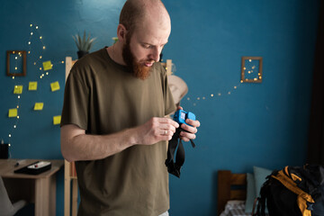 bald man preparing for a hike holding an action camera to shoot mountain landscapes