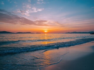 Fototapeta premium Beach scene with waves rolling to shore as sun dips toward the horizon, colors bright