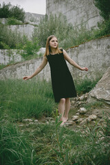 A young woman walking barefoot in black dress outdoors