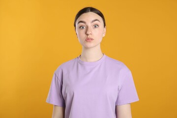 Portrait of confused woman on orange background