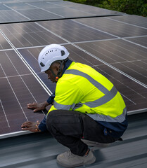 Black solar engineer man working with solar panels on roof
