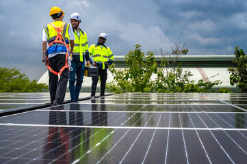 Group of photovoltaic engineer men working together inspecting solar panels on building roof