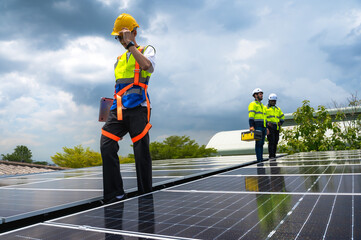 Group of photovoltaic engineer men working together inspecting solar panels on building roof