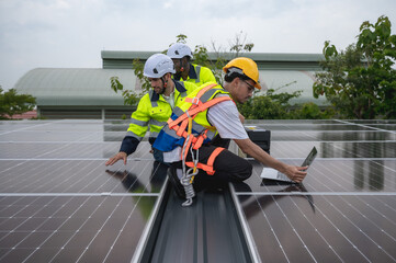Group of photovoltaic engineer men working together inspecting solar panels on building roof