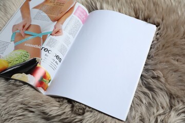 Open magazine on faux fur, closeup. Mockup for design
