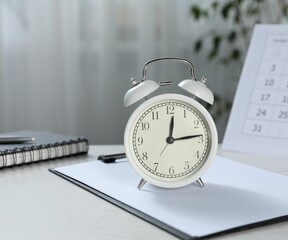 Deadline. Alarm clock, stationery and calendar on light table indoors