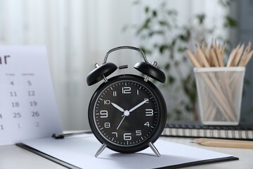Deadline. Alarm clock, stationery and calendar on table indoors