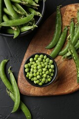 Fresh ripe green peas on black table, flat lay