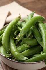 Fresh ripe green peas on wooden table, closeup