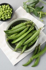 Fresh ripe green peas on grey table, flat lay