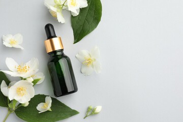 Cosmetic product and jasmine flowers on light background, flat lay. Space for text