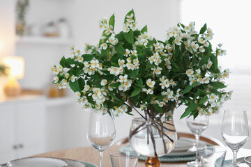 Bouquet of beautiful jasmine flowers on dining table indoors