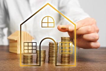 Increase in real estate value. Woman stacking coins at table, closeup. Illustration of house