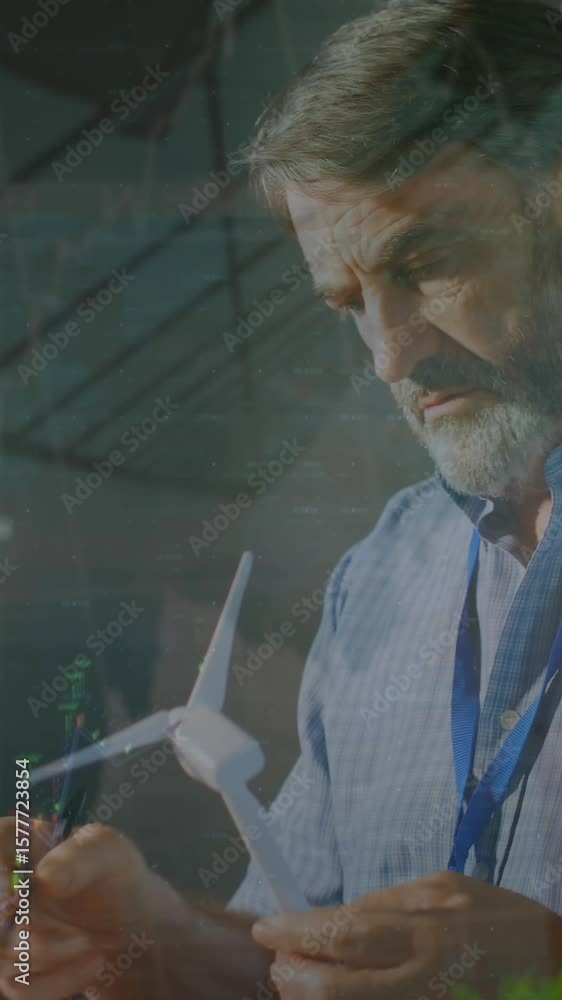 Poster animation of graphs, numbers over caucasian engineer inspecting windmill model and writing in book