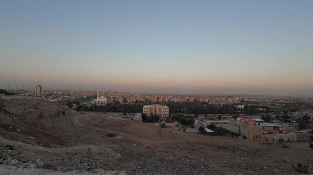 Cityscape at Dusk with Mosque and Barren Land. Aleppo, Syria