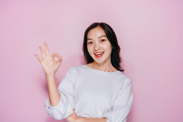 Asian Woman Smiling and Making Okay Sign on Pink Background - Positive Emotion Communication Concept for Advertising and Social Media Content
