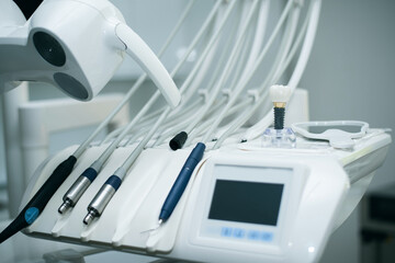 Close-up of dental chair instruments and a model of a dental implant on top