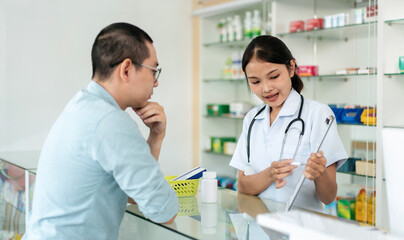 A woman in a white lab coat is talking to a man in a white shirt