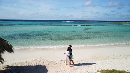 young couple walking on the beach in aruba