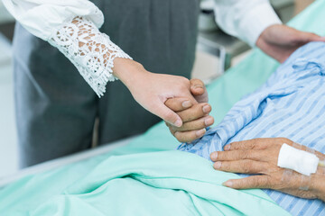 Terminally ill patients and their relatives in a hospital room. Sick patient lying on bed in hospital.