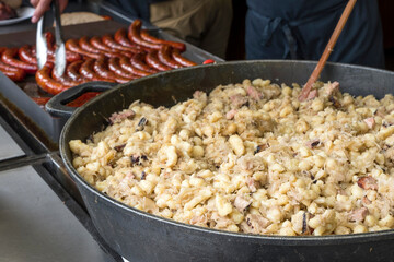 Spätzle y salchichas a la parrilla en un puesto callejero de Praga, República Checa