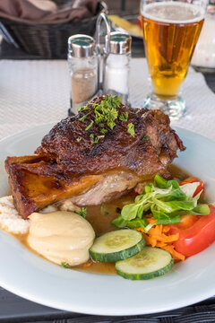 Codillo de cerdo con salsas y ensalada en un restaurante de Praga, Rep&uacute;blica Checa.
