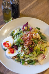 Ensalada con huevos y trozos de bacon