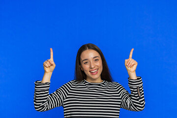 Caucasian happy woman showing thumbs up pointing overhead empty place, advertising area for...