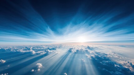 A breathtaking aerial view of a sunlit sky above fluffy clouds with dramatic light rays spreading across the horizon.