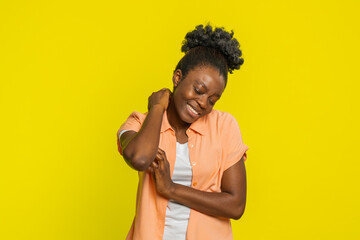 African American woman scratches hand arm and neck, showing irritation frustration from allergy...