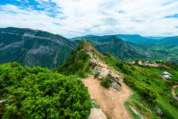 Picturesque mountain landscape with a photo tower of the Russian fortress in Gunib and tourists. Dagestan, Caucasus
