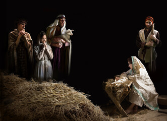 Mary sits in the stable near the manger with the baby