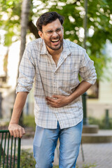 Arabian young man traveler feeling sudden strong abdominal stomach ache, gastritis problem. Upset...