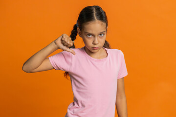Dislike. Upset young preteen child girl kid showing thumbs down sign gesture, expressing...