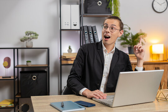Smiling young Caucasian man freelancer thinking finding a good idea typing on laptop. Professional businessman writing important email from home at table. Happy guy working online remote distance job - Powered by Adobe