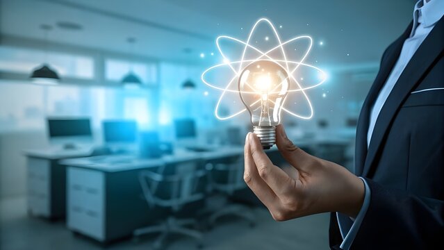 Businessman holding a glowing light bulb with atomic orbits representing innovation and scientific discovery